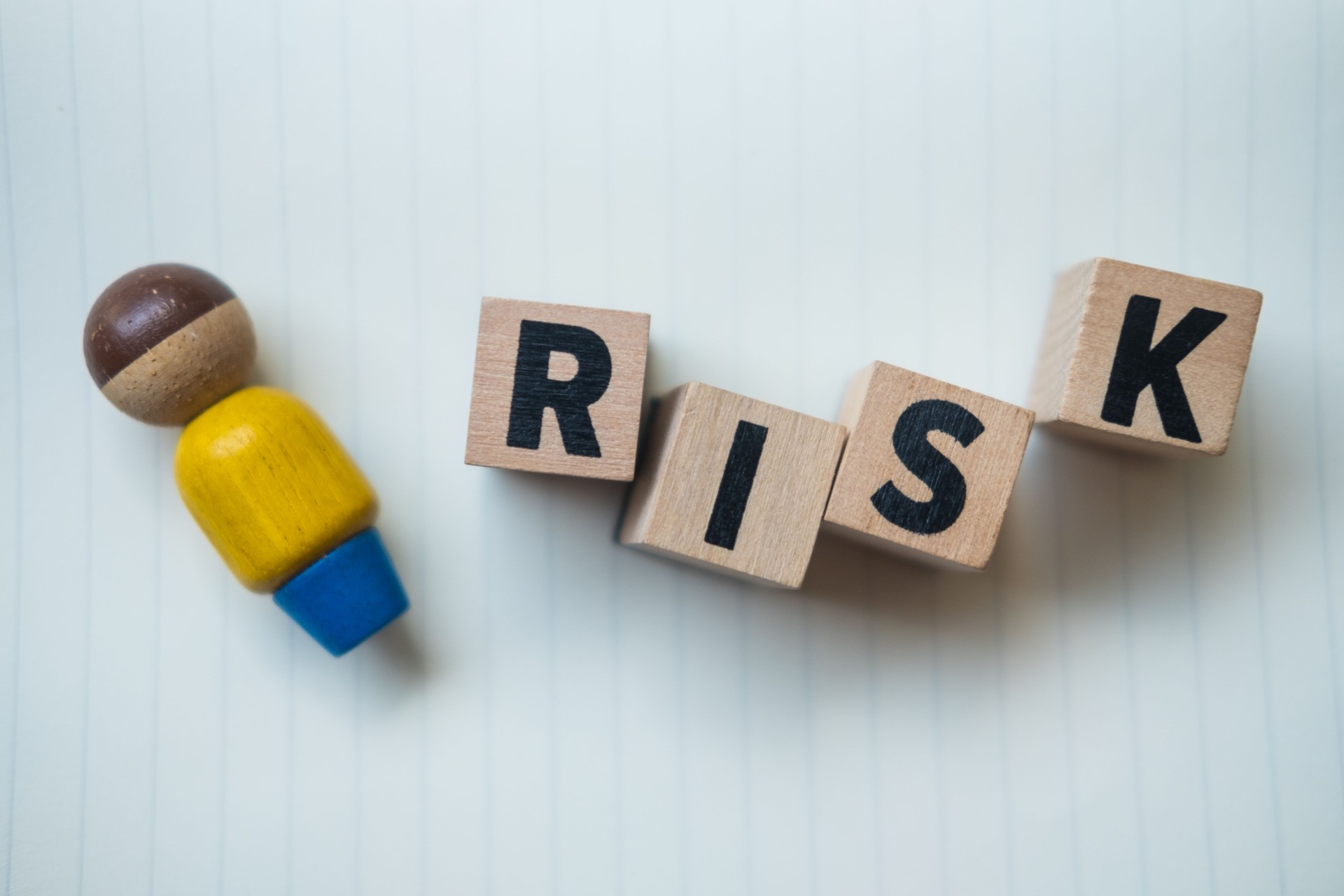 Wooden blocks with the word RISK and leader. Business concept of crisis solution and problem management.